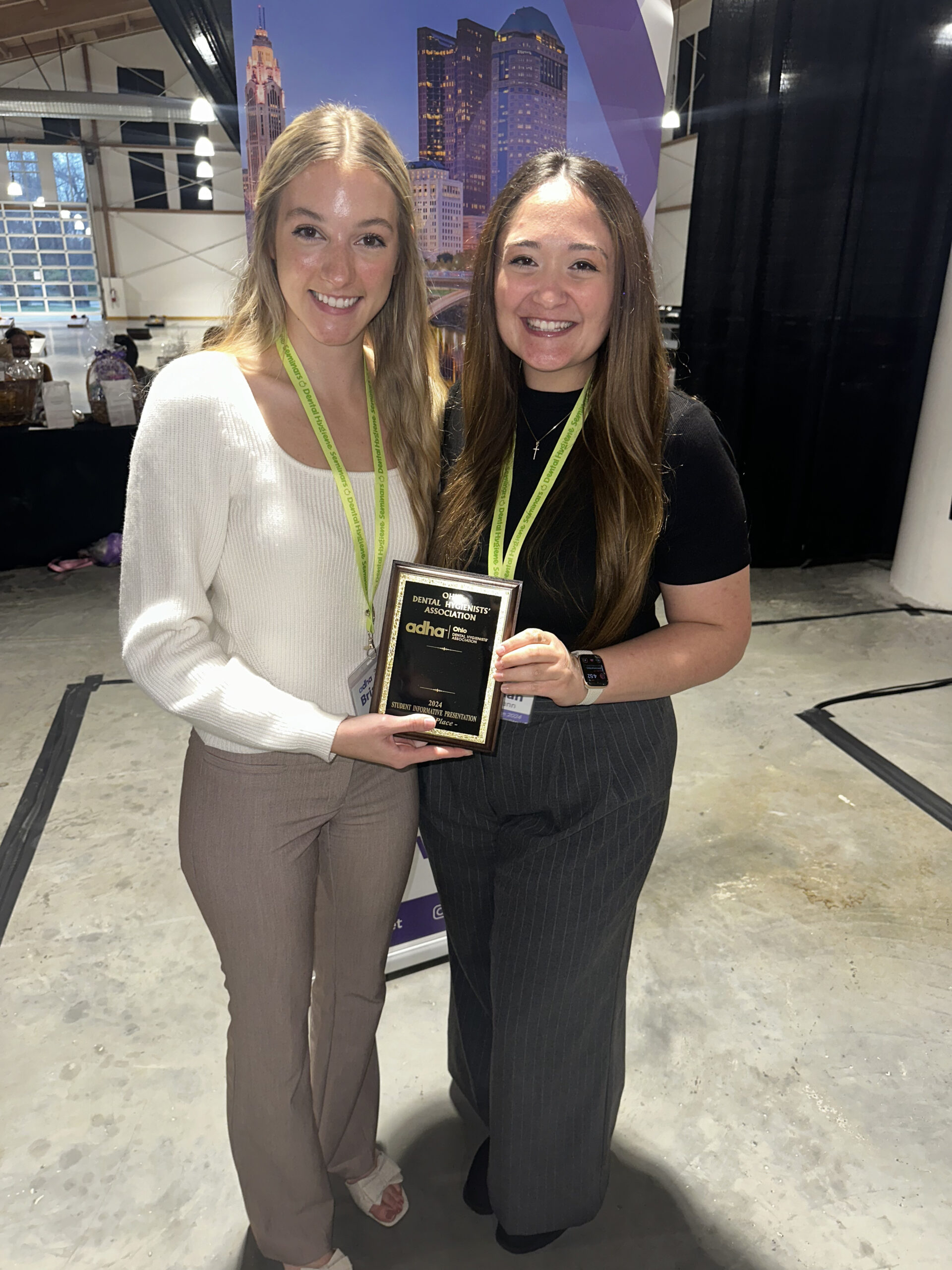 Two women standing next to each other holding a plaque.